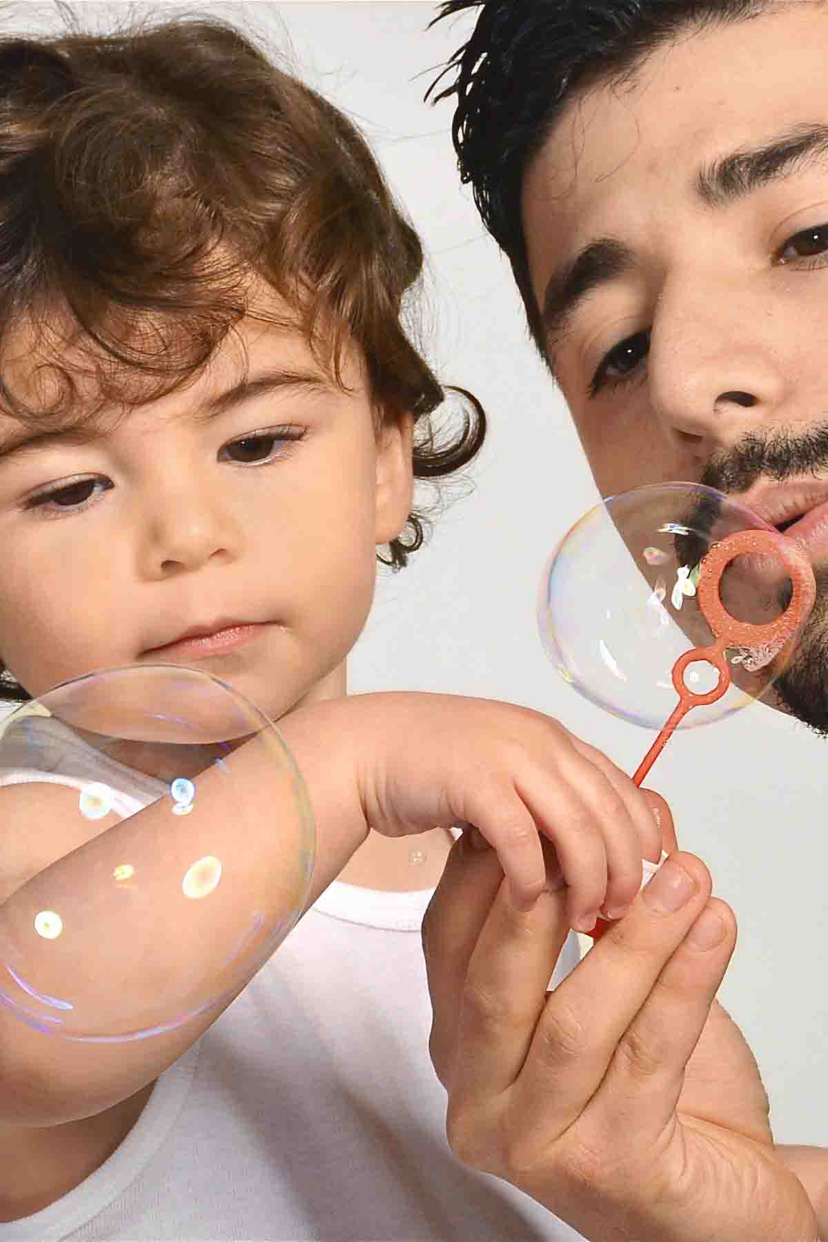 Father and son blowing bubbles Fetcham,Surrey.